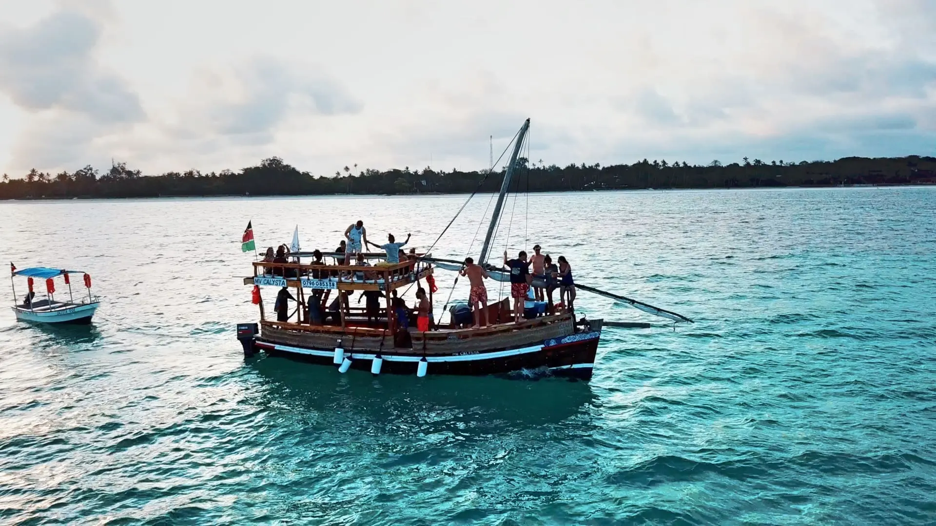 groep reizigers op houten dhow boot op turkoois water bij Keniaanse kust