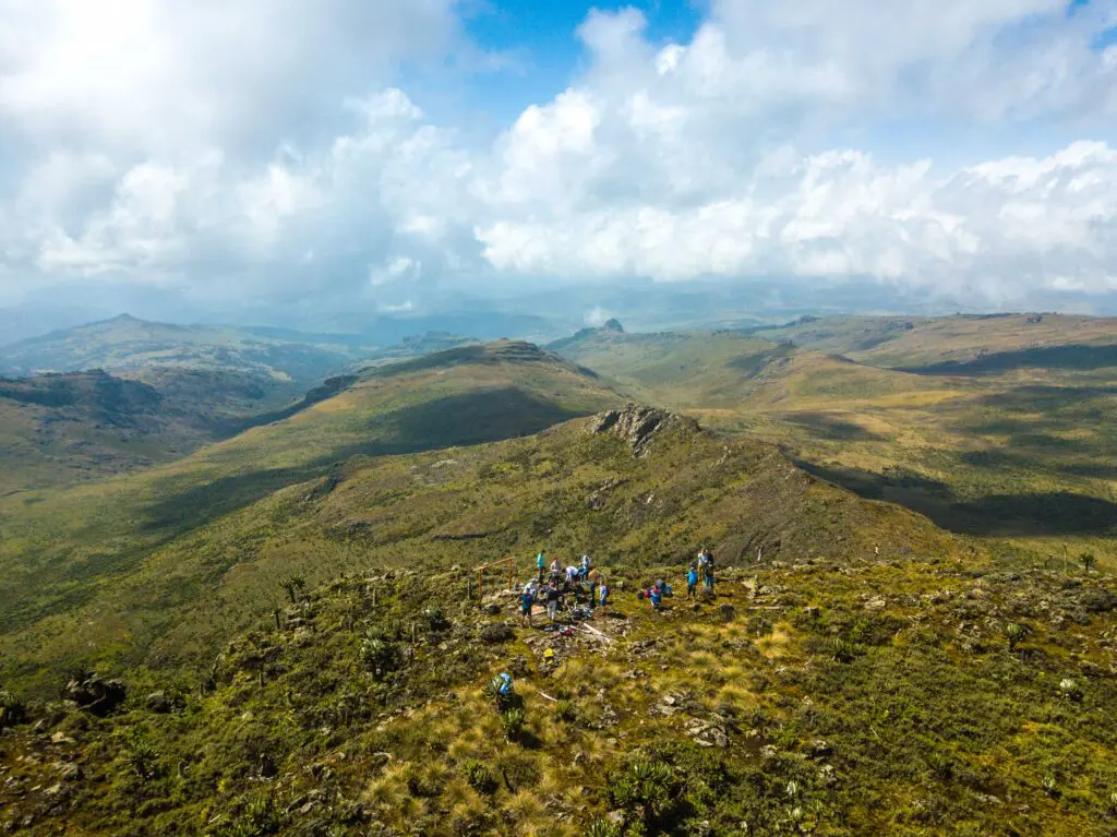Groep wandelaars bereikt een bergtop met panoramisch uitzicht in Mount Elgon