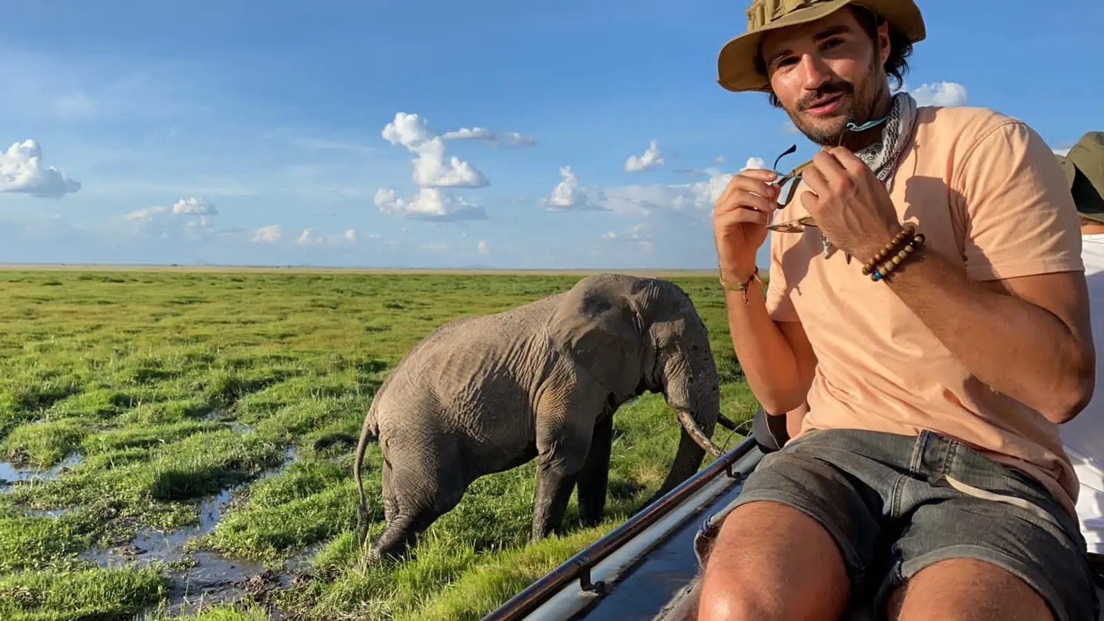 man op safari in Kenia met een olifant dichtbij in het moerasland