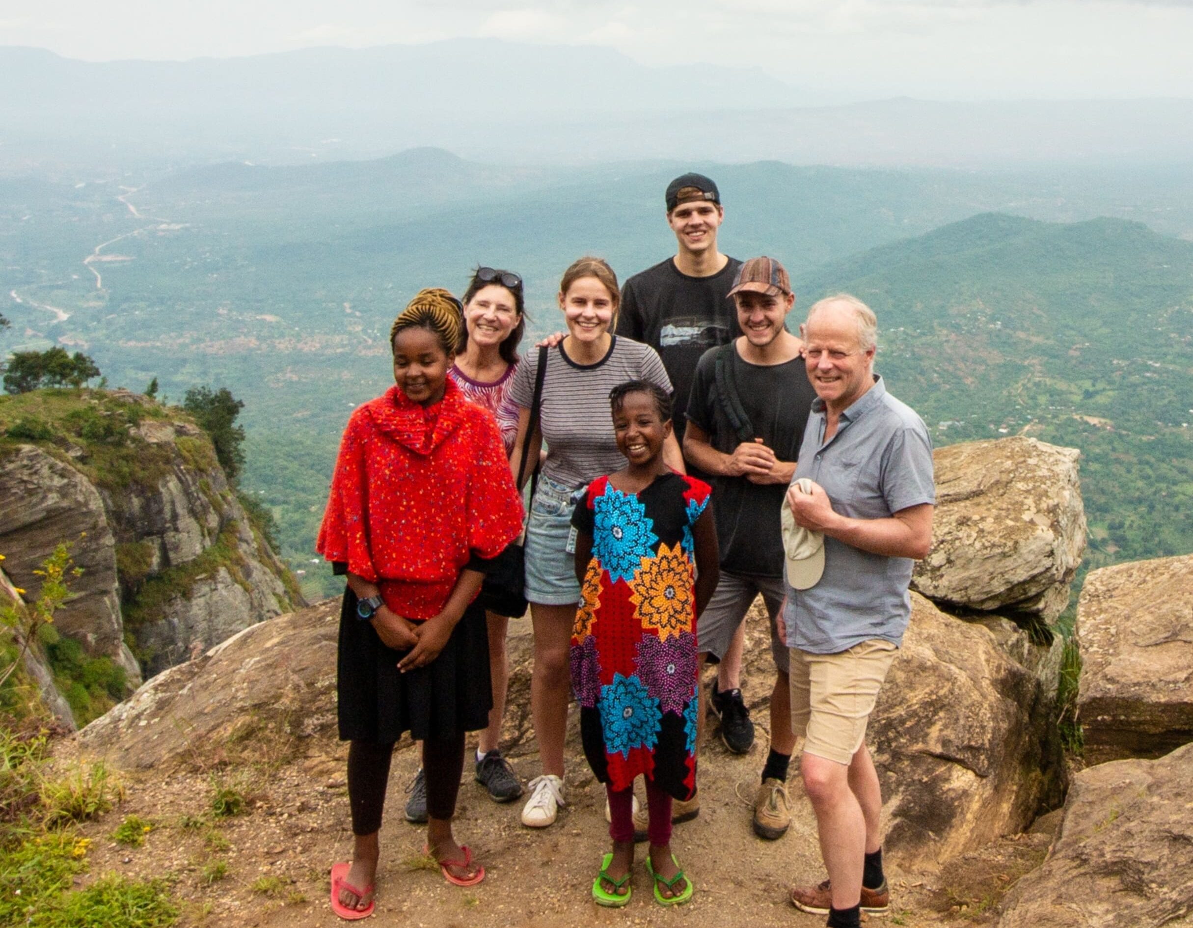 groep reizigers met lokale kinderen op uitzichtpunt in de Taita Hills in Kenia