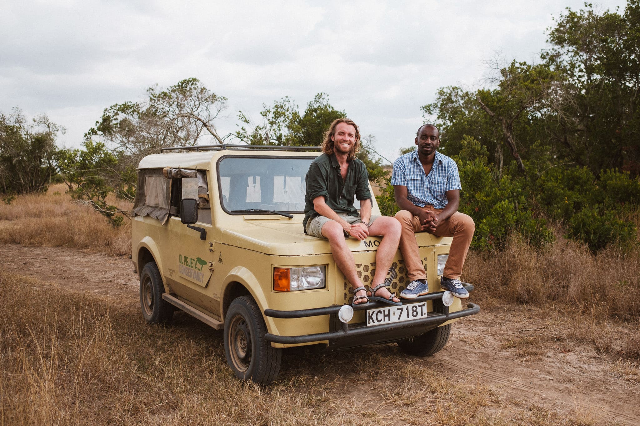 Twee mannen zitten op een safari jeep in Ol Pejeta Conservancy in Kenia