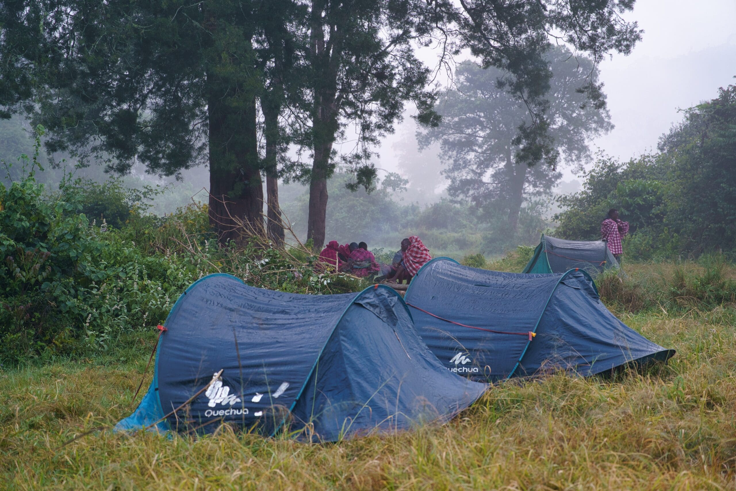 Kampeerplek in de mistige Loita Hills Kenia met tenten en Maasai bij een kampvuur