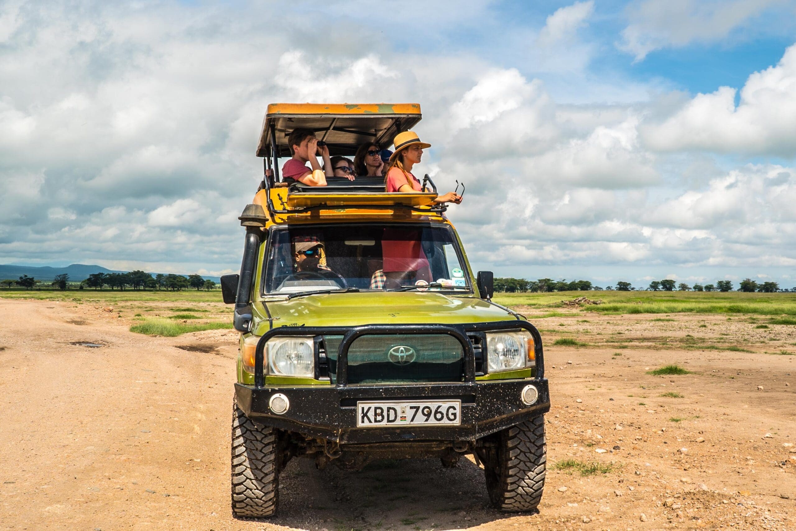 groep toeristen in een groene safari jeep tijdens game drive in Kenia