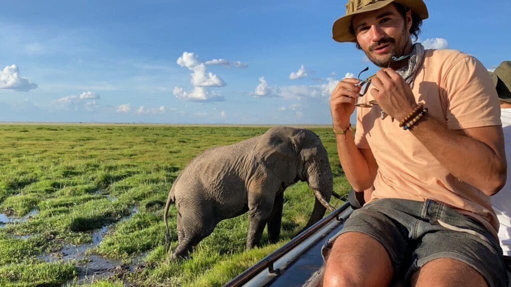 man op safari in Kenia met een olifant dichtbij in het moerasland